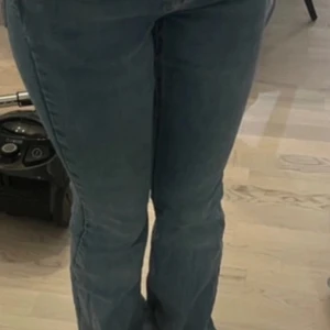 Blå jeans med bootcut - Säljer ett par klassiska blå jeans med bootcut-stil. De är i bra skick och har en snygg tvätt som passar perfekt till vardags. Jeansen har en knapp och dragkedja framtill samt fem fickor. Perfekta för både höst och vår!
