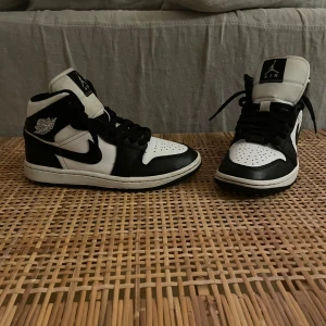 Nike Air Jordans i svart och vit - Säljer ett par snygga Nike Air Jordans i svart och vit. Skorna är i nyskick och har klassisk snörning. Perfekta för både vardag och fest! Storlek  37.5. Passa på att få tag i dessa stilrena sneakers!