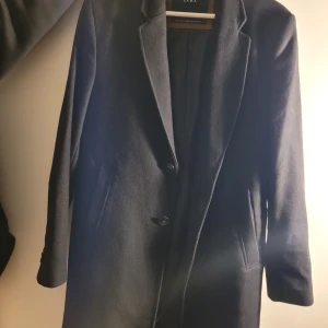 Svart kappa från Zara  - Snygg svart kappa med fickor. Knappar framtill. Meddela för mer bilder