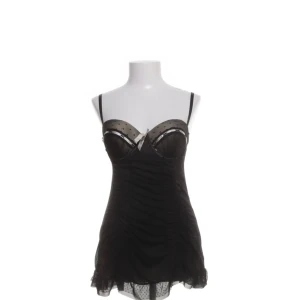 Svart klänning/negligé - Snygg svart kortklänning med tunna axelband och spetsdetaljer. Den är väldigt kort så funkar även som ett linne! Den har en öppen rygg med snörning och volangkant nedtill. Perfekt för en festkväll eller till vardagen