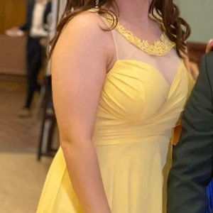 Gul klänning med axelband - Säljer en superfin gul klänning med smala axelband och en härlig, flödande kjol. Perfekt för sommarens fester eller en solig dag. Och passar perfekt för en släkts eller kompis bröllop, bal. Klänningen har en vacker passform som ger en elegant look.