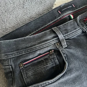 Tommy Hilfiger Jeans - Svarta slim fit Tommy Hilfiger jeans med sköna detaljer som visas på bilderna😍  10/10 skick, storleken är 32-34 men passar mindre. 