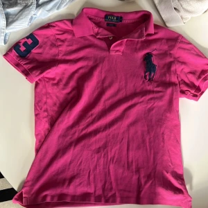 Rosa pikétröja från Ralph Lauren - Säljer en snygg rosa pikétröja från Ralph Lauren i storlek M. Tröjan är i slim fit och har en klassisk krage med knappar. Den är tillverkad i 100% bomull, vilket gör den superbekväm. Perfekt för både vardag och festliga tillfällen! Kom med bud😁👍