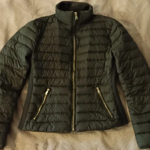 Svart dunjacka från Zara Woman - Säljer en snygg och varm svart dunjacka från Zara Woman. Jackan har en dragkedja framtill och två praktiska fickor med dragkedjor. Den är quiltad och har en hög krage som skyddar mot kyla. Perfekt för höst och vinter!