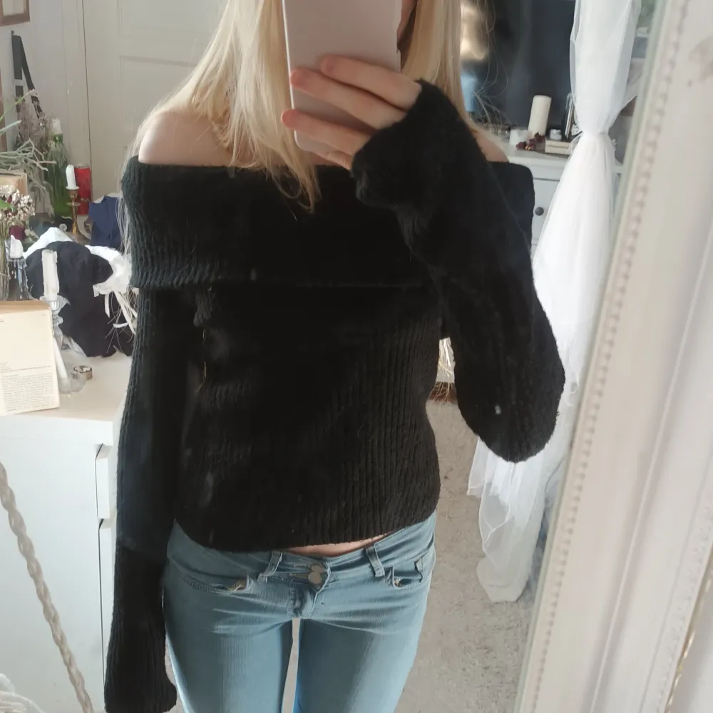 Säljer en superfin svart offshoulder tröja som är perfekt för både vardag och fest. Den är stickad och har långa ärmar, vilket gör den mysig och stilren. Passar perfekt till jeans eller kjol för en chic look! Lite nopprig men varm.. Tröjor & Koftor.