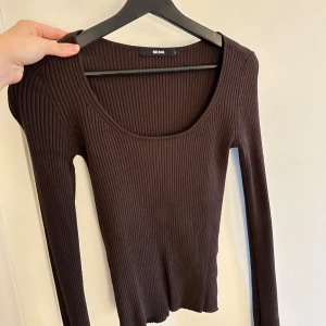 Brun ribbad tröja från Bik Bok - Säljer en snygg brun ribbad tröja från Bik Bok. Den har en djup rund hals och långa ärmar, perfekt för höst och vinter. Tröjan är i bra skick och passar både till vardags och fest. Superbekväm och stilren!