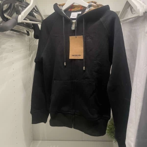 Burberry zip up hoodie - Svart burberry hoodie i storlek M men passar även S. Skick 10/10 använd 1 gång. Köpt för 1599:- mitt pris 965:-