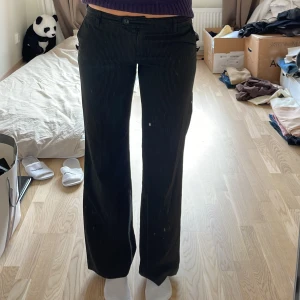 Randiga lågmidjade byxor  - Lågmidjade byxor, en knapp har gått av men dom går att stänga ändå o om man vill kan man du på den igen. Lapp finns ej men gissar på strlk 38/40. Jag är 177. Midja: 42cm Innerben: 80cm 