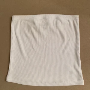 Tube top - Vit tub topp i storlek M. Stretchigt material. Använd fåtal gånger, i perfekt skick.