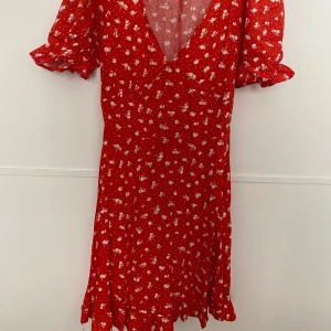 Rödblommig sommarklänning  - Rödblommig sommarklänning från H&M. Aldrig använd och säljs då den inte passar mig. Pris går att diskutera.