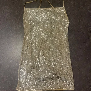 Glittrig klänning - Glittrig klänning med korsad rygg från H&M