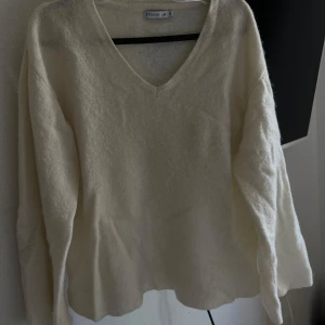 Vit ulltröja från Stockh LM - Mysig vit ulltröja från Stockh LM i storlek XS. Den har en v-ringad design och långa ärmar, perfekt för kyliga dagar. Tröjan är supermjuk och håller dig varm hela vintern!