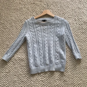 Ljusblå stickad tröja från H&M - Säljer en superfin ljusblå stickad tröja från H&M. Den har ett klassiskt flätmönster och trekvartsärmar, perfekt för både vår och höst. Tröjan är i bra skick och passar till både jeans och kjol. Perfekt för en casual look!