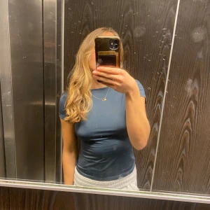 T-shirt med öppen rygg - Jättefin t shirt med öppen rygg från weekday. Använd 1-2 gånger och säljer därför att den inte kommer till användning för mig💚kontakta först vid intresse innan köp💕