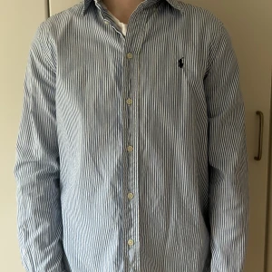 Randig skjorta från Ralph Lauren - Hej! Säljer min polo Ralph lauren skjorta! Skick 8/10. Säljer den för ja har växt ifrån den! Jag är 175 och den är kort i armen. Rekommenderar till nån 170cm eller under. Storlek xs-s! PRIS KAN DISKUTERAS VID SNABB AFFÄR!
