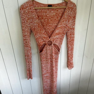 Orange mönstrad långklänning - Lång klänning som kan se väldigt liten ut men som är väldigt stretchig och sitter väldigt fint på