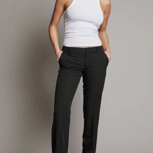 Svarta kostymbyxor från Bik Bok - Snygga svarta kostymbyxor från Bik Bok med en klassisk design. Byxorna har en rak passform och är perfekta för en stilren look. De har en dragkedja och knappar framtill för enkel stängning.