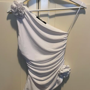 Vit oneshoulder topp  - Elegant vit oneshoulder topp med rosor