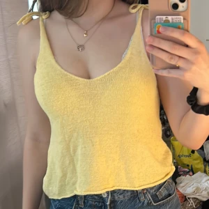 Gul linnetopp från H&M Divided - Säljer en söt gul linnetopp från H&M Divided. Toppen har en v-ringad design. Perfekt för varma sommardagar. Passar bra till jeans eller shorts. 🌼Säljer då den inte använts hos mig.