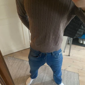 Brun kabelstickad tröja från J.Lindeberg - Säljer en snygg brun kabelstickad tröja från J.Lindeberg i storlek L men jag skulle säga att den sitter som en M. Tröjan har en klassisk design med ribbade muddar vid ärmslut och nederkant. Inga defekter och bra skick. Tvek inte på att ställa frågor😊ny pris ca1350kr