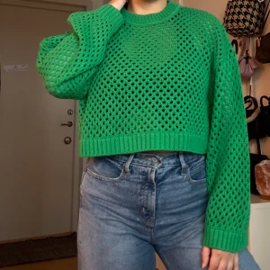 Grön stickad tröja - Grön stickad tröja med ett hålmönster. Tröjan är croppad och har långa vida ärmar. Väldigt skönt material, inte alls stickig :) 