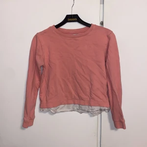 Rosa tröja från 157 - Säljer en söt rosa tröja från 157 med en vit detalj vid nederkanten. Tröjan har långa ärmar och en rund halsringning. Perfekt för en avslappnad stil. Passar bra till jeans eller kjol. 🌸