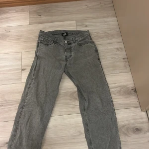 Grå jeans från Sweet Sktbs - Snygga grå jeans från Sweet Sktbs med klassisk femficksdesign och knappgylf. Perfekta för en avslappnad stil med en skandinavisk touch. Köpa på junkyard. Org pris: 800