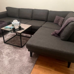 Grå hörnsoffa - Säljer en stilren och bekväm grå hörnsoffa med plats för många. Soffan har en modern design med raka linjer och svarta ben. Perfekt för vardagsrummet och ger en elegant touch till inredningen.