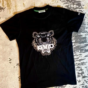 Kenzo t-shirt - Snygg svart t-shirt från Kenzo. T-shirten är i bomull och har en normal passform. Kenzo-loggan syns tydligt på ärmen.