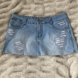 Ljusblå jeanskjol - Jättesnygg och trendig ljusblå lågmidjad jeanskjol med coola slitningar, midjemått ca 37 cm rakt över, längd ca 28 cm 🥰lite stretchig i materialet 💕💕priset är inte diskuterbart!