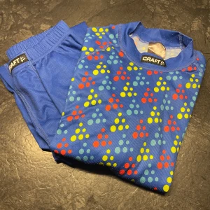 Craft underställ - Säljer ett underställ från Craft med ett färgglatt prickigt mönster i rött, gult och grönt. Perfekt för den som gillar att sticka ut med färg. Tröjan har långa ärmar och är gjord i ett mjukt material.