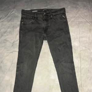 Svarta jeans från Replay - Snygga svarta jeans från Replay med en klassisk femficksdesign. De har en knappgylf och en diskret logga på bakfickan. Perfekta för en stilren look. W32 L34