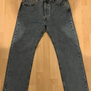 Levi's 501 jeans - Klassiska Levi's 501 jeans i en snygg ljusblå  färg. De har en rak passform och är tillverkade i slitstarkt denim. Perfekta för en avslappnad stil och har knappgylf. Jeansen är mer åt det baggy hållet.