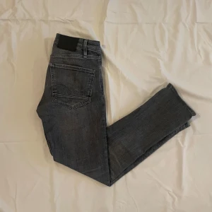 Grå och mörkblå jeans - Två par jeans i olika nyanser. Ett par är gråa och det andra är mörkblått. Båda har en klassisk femficksdesign och en rak passform. Perfekta för en avslappnad stil. Båda jeansen är storlek W28 L30 och har modellen slim straight Tim och är ifrån Jack and jones. Köp ett par för 299kr eller köp båda för 499. Hör av dig vid fråga eller fundering. Mvh Levi!