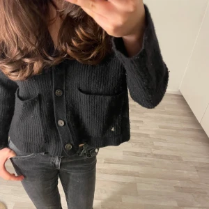 Ralph lauren kofta - Säljer en svart stickad kofta med knappar framtill och två fickor. Koftan har långa ärmar och en klassisk design som passar perfekt till vardags. Den är mjuk och bekväm att bära.