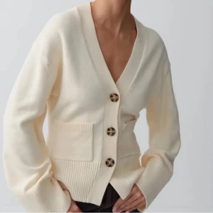 Krämvit stickad kofta med knappar - figursydd, slutsåld kofta från gina som sitter jättefint på kroppen och är superskön💗köpt för 500 endast testad