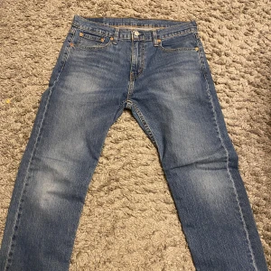  Falkenberg  - Snygga blå jeansbyxor med klassisk design. De har en normal passform och är tillverkade i slitstarkt denim. Perfekta för en avslappnad stil med fem fickor och knappgylf.