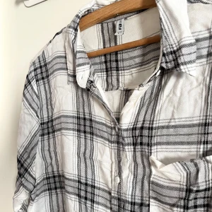 Vit flanellskjorta  - Vit flanellskjorta med svarta rutor, mjukt och flowy material! Sitter som S/M. Har använts en del, men finns inga fläckar eller märken! Alla använda plagg tvättas noga innan leverans! Det är bara att skriva om du har några frågor! <3  