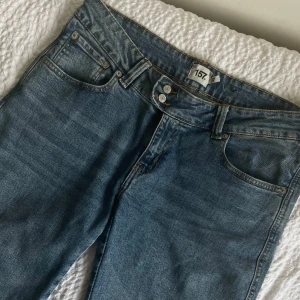 Blå jeans från 157 - Snygga blå jeans från 157 med klassisk femficksdesign och knappgylf. Perfekta för en avslappnad stil. De har en utsvängd passform och är tillverkade i ett slitstarkt denimtyg.