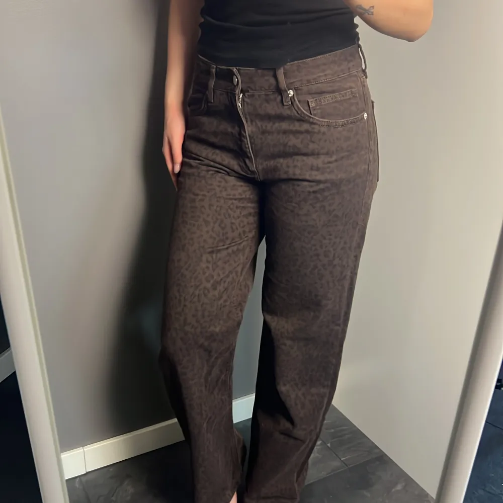 Snygga bruna jeans med leopardmönster. Byxorna har en hög midja och är raka i passformen.. Farkut & Housut.