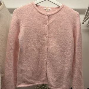 Rosa kofta från Gina Tricot - Säljer en söt rosa kofta från Gina Tricot. Den har långa ärmar och knäpps med knappar framtill. Perfekt för en mysig dag eller som ett extra lager under kyliga kvällar. 💖