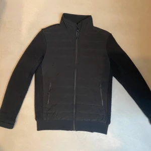 Svart cardigan från Superdry - Säljer nu en riktigt fet cardigan från superdry. Jackan är bara använd ett fåtal gånger! Den är i storlek S och har den klassiska cardigan designen. Ärmarna är rätt så tjocka så den passar bra både på hösten, våren och vintern. Tveka inte på att höra av er vid frågor och funderingar.