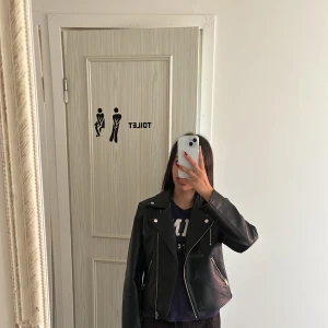 Kort skinnjacka  - Kort svart skinnjacka  Med knapp och kedje detaljer  Storlek XS