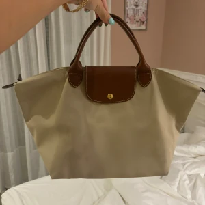 Longchamp väska! - En super fin beige longchamp perfect till hösten och skolan💗💗Väskan är i medium modellen, en stor iPad eller nyaste macbooken får plats💗‼️