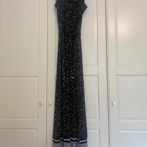 Michael kors  - Jätte skön och svalt lång klänning från Michael kors med dragkedja i bak och band  runt midjan med guld detaljer, samt en liten öppning vid halsen. Använd 2 korta stunder så vill att den kommer till användning mer än i min garderob, Storlek S