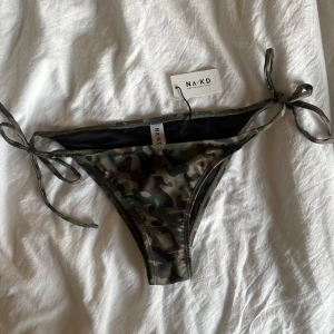 Bikini underdel  - Kamouflage färgad bikini underdel med knytning på sidorna från Na-Kd som är helt ny! 