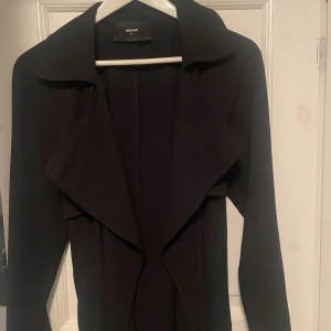 trenchcoat - En tunn trenchcoat från BikBok storlek M