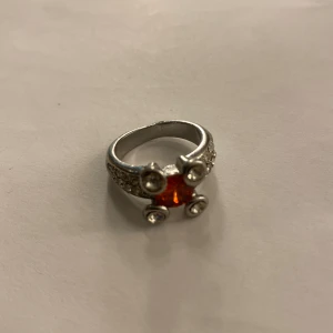 Ring  - En ring med en röd diamant/sten. 