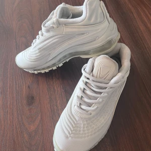 Vita Nike sneakers - Säljer ett par vita Nike AirMax 97 sneakers i nyskick. Nypris 1398kr De har en stilren design med snörning och en bekväm sula. Perfekta för både vardag och träning! Storlek 37. 