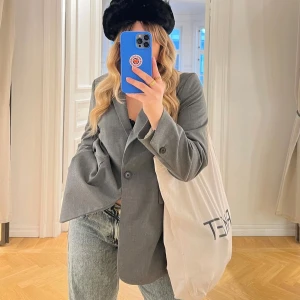 Grå kavaj från H&M - Säljer en stilren grå kavaj från H&M i storlek M. Kavajen har en klassisk design med knappar framtill och långa ärmar. Perfekt för både vardag och festliga tillfällen. Den är i jättebra skick!som ny!